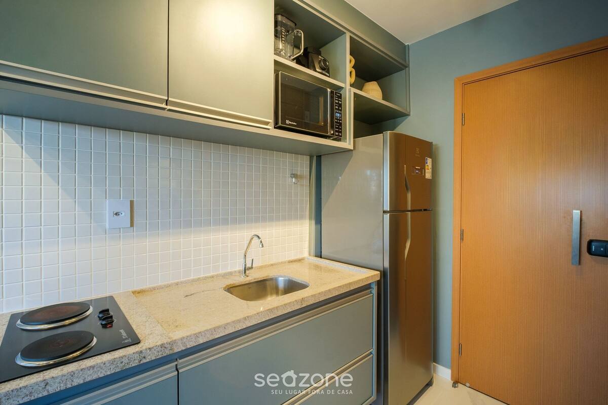 A kitchen with a built-in microwave, a sink, and a stove.