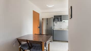 A compact kitchen with a refrigerator, microwave, and sink.