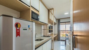 Eine kleine Küche mit Kühlschrank, Mikrowelle und Spüle.