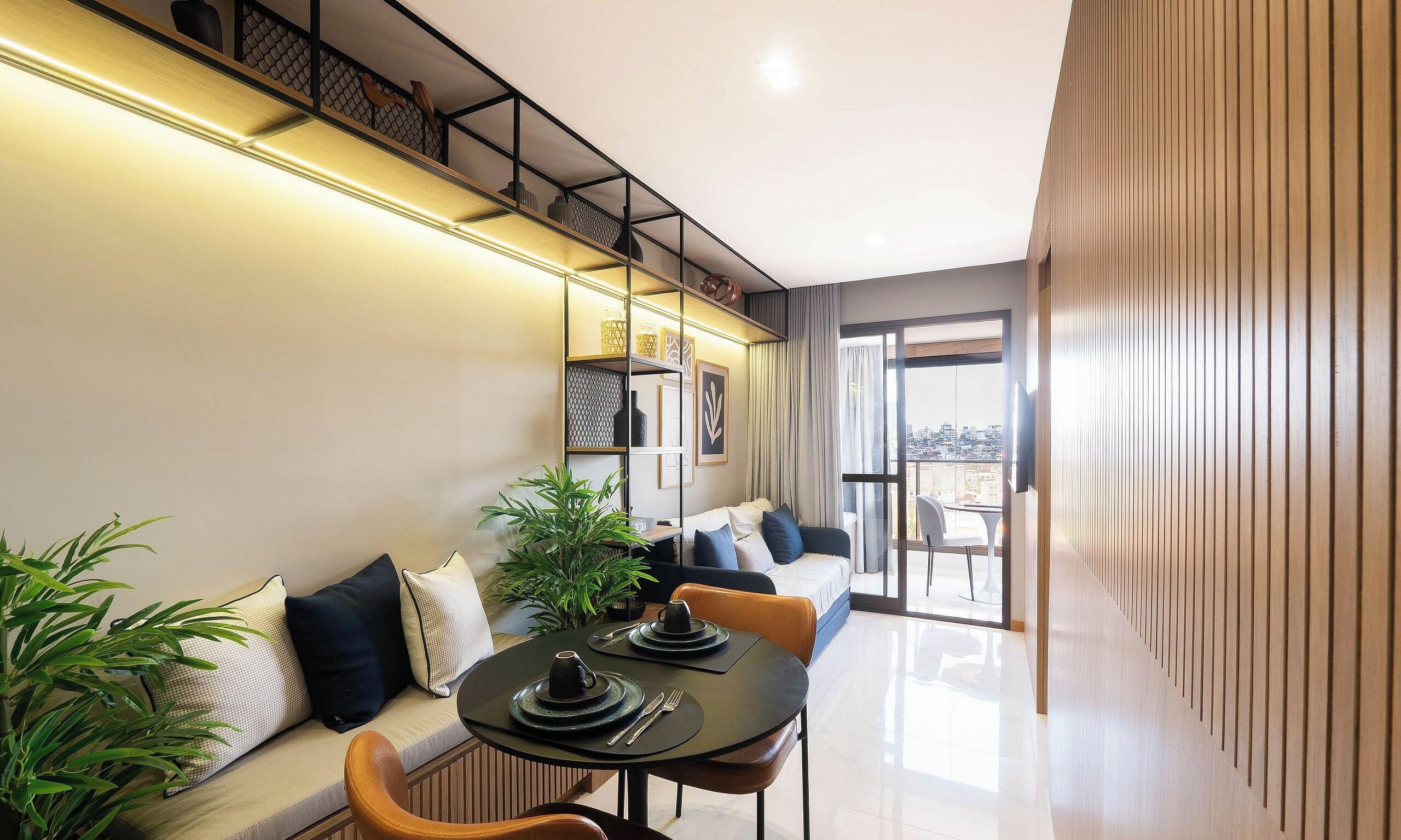 A modern dining area with a long table, chairs, and a sofa.