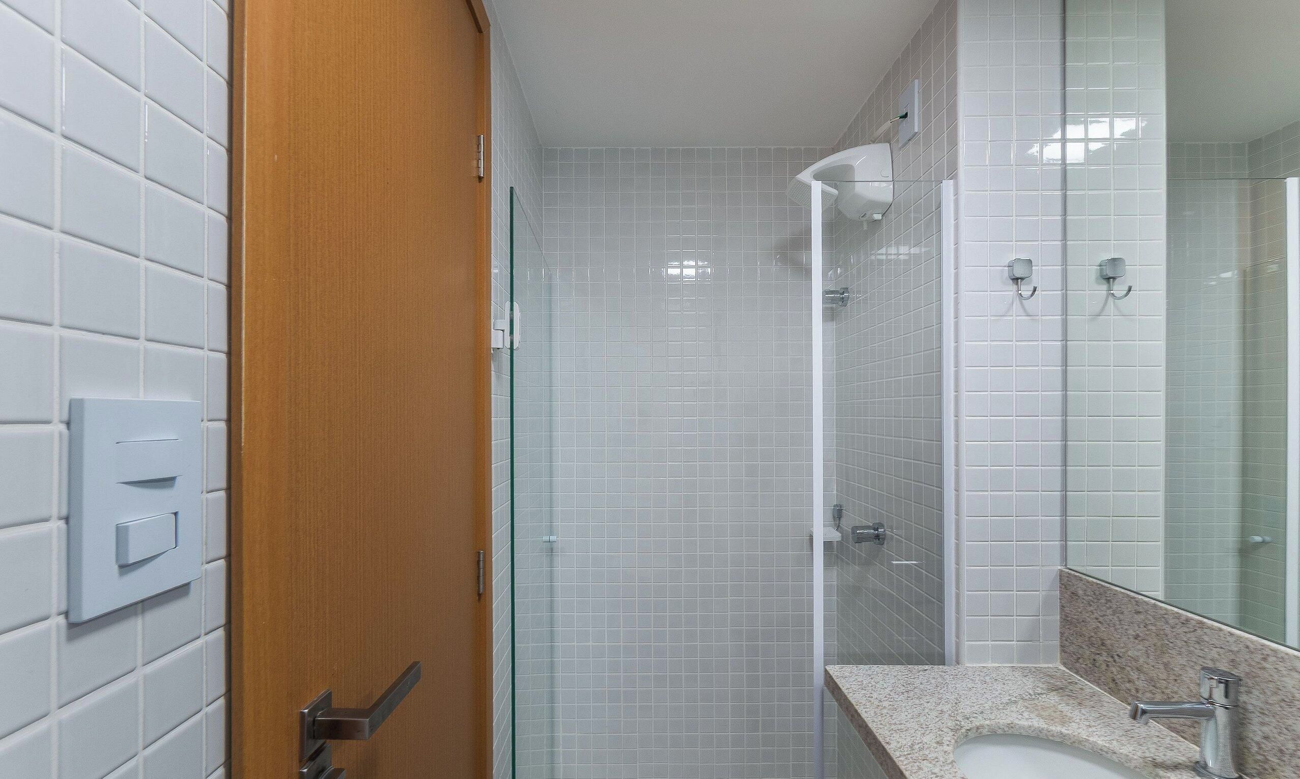 Un bagno con doccia, lavabo e specchio.