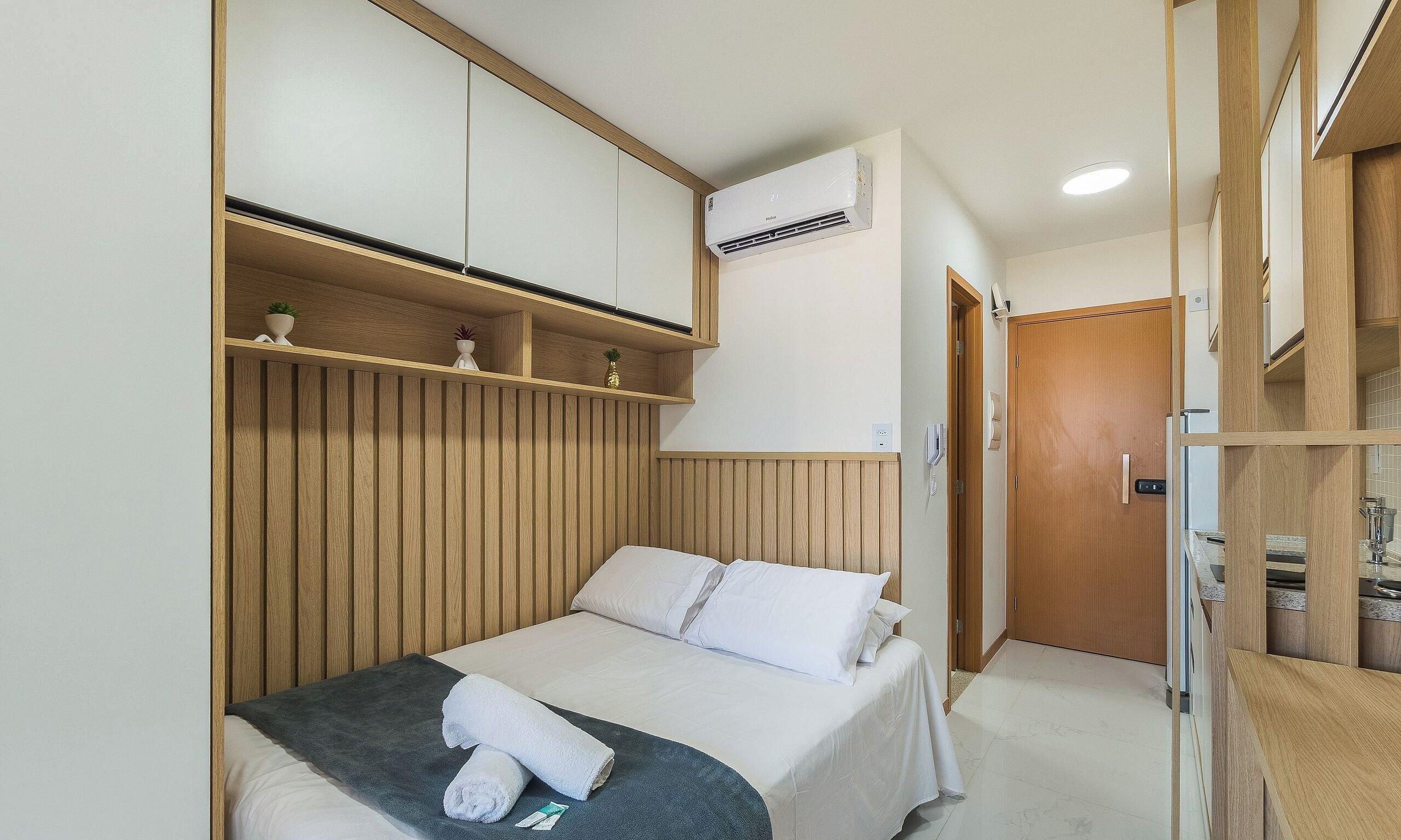 Een hotelkamer met een bed, een kledingkast, een badkamer en een ingebouwde airconditioning.
