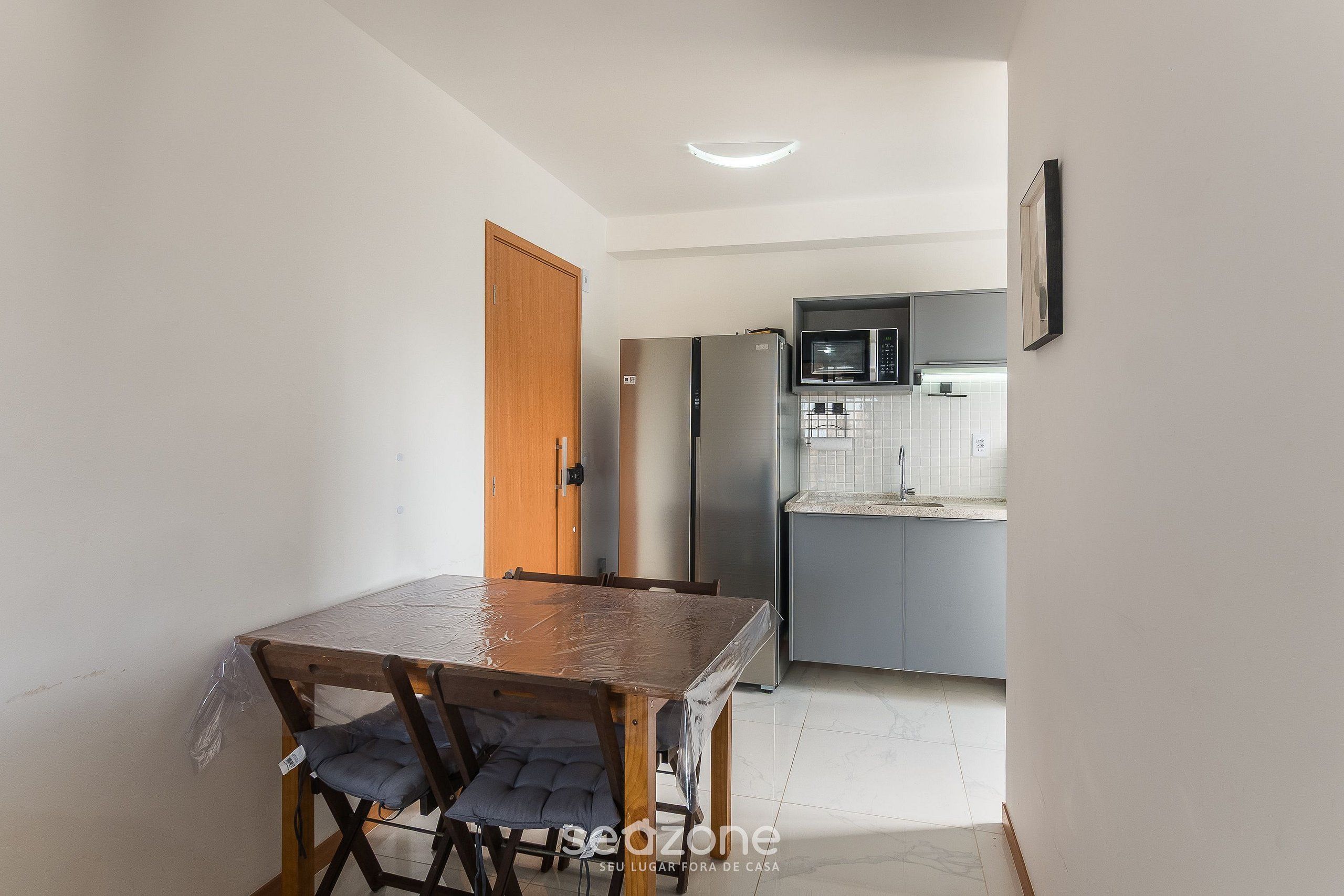 Cucina compatta con frigorifero, forno a microonde e lavello.