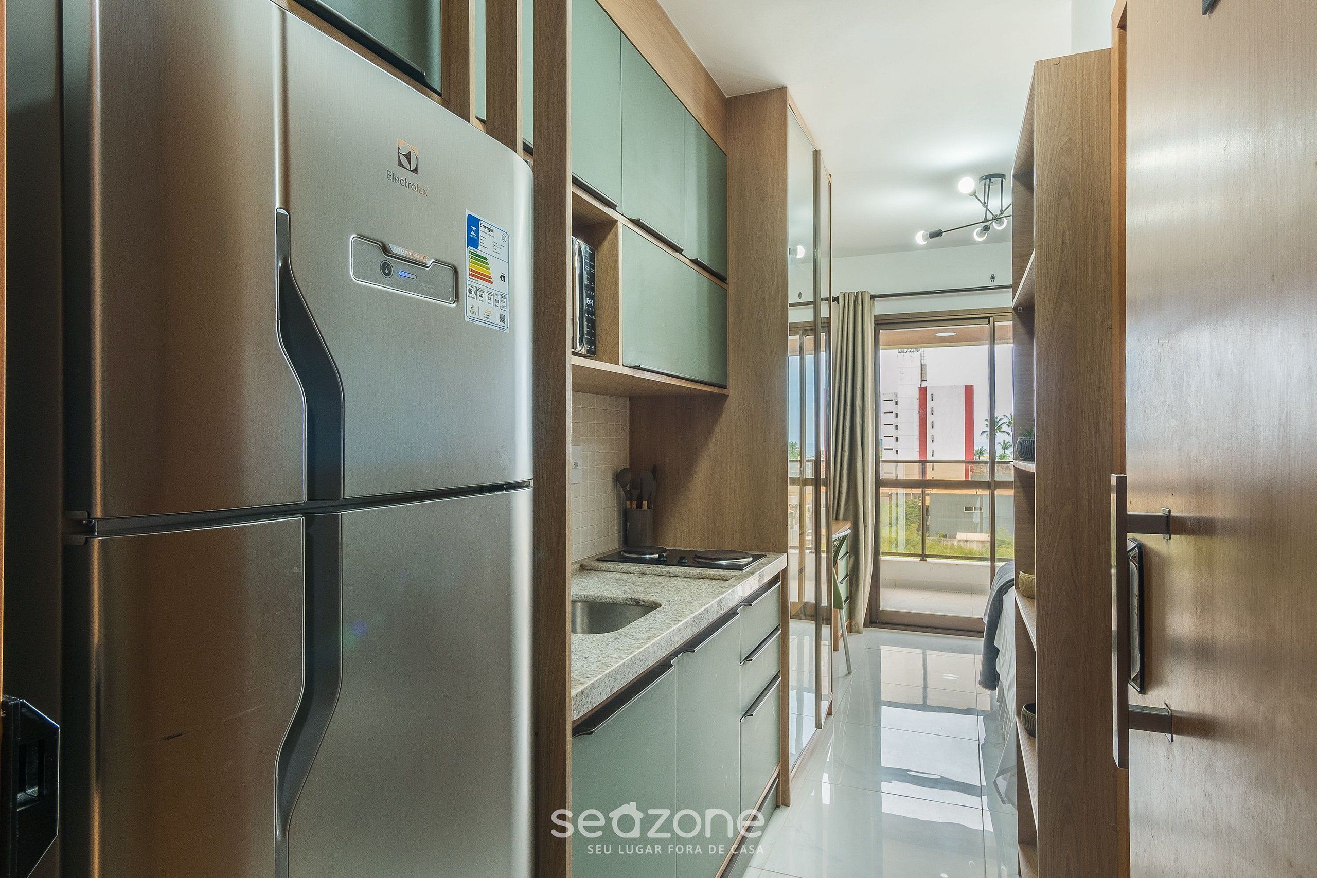 Una cocina moderna con electrodomésticos de acero inoxidable, armarios de madera y vistas al exterior.