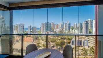 A balcony with a view of a cityscape and the sea.
