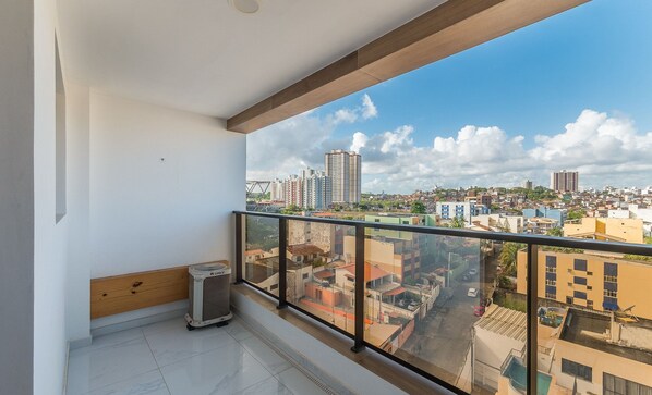 A balcony with a city view, a GREE air conditioner, and a tiled floor.