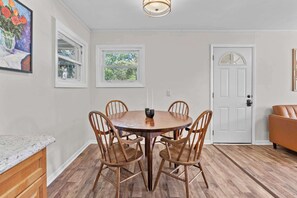 Cozy dining area with a round table and comfortable seating for four, featuring a beautiful view of the surrounding greenery.