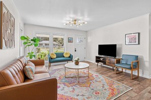 Relax in this stylish living room with a leather sofa, armchair, and flat-screen TV.