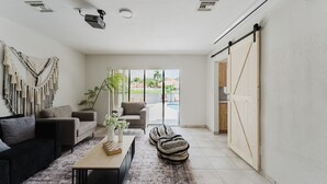 A modern living room with a sofa, armchairs, a coffee table, and a patterned rug. - Tulum Villa (Pembroke Pines)