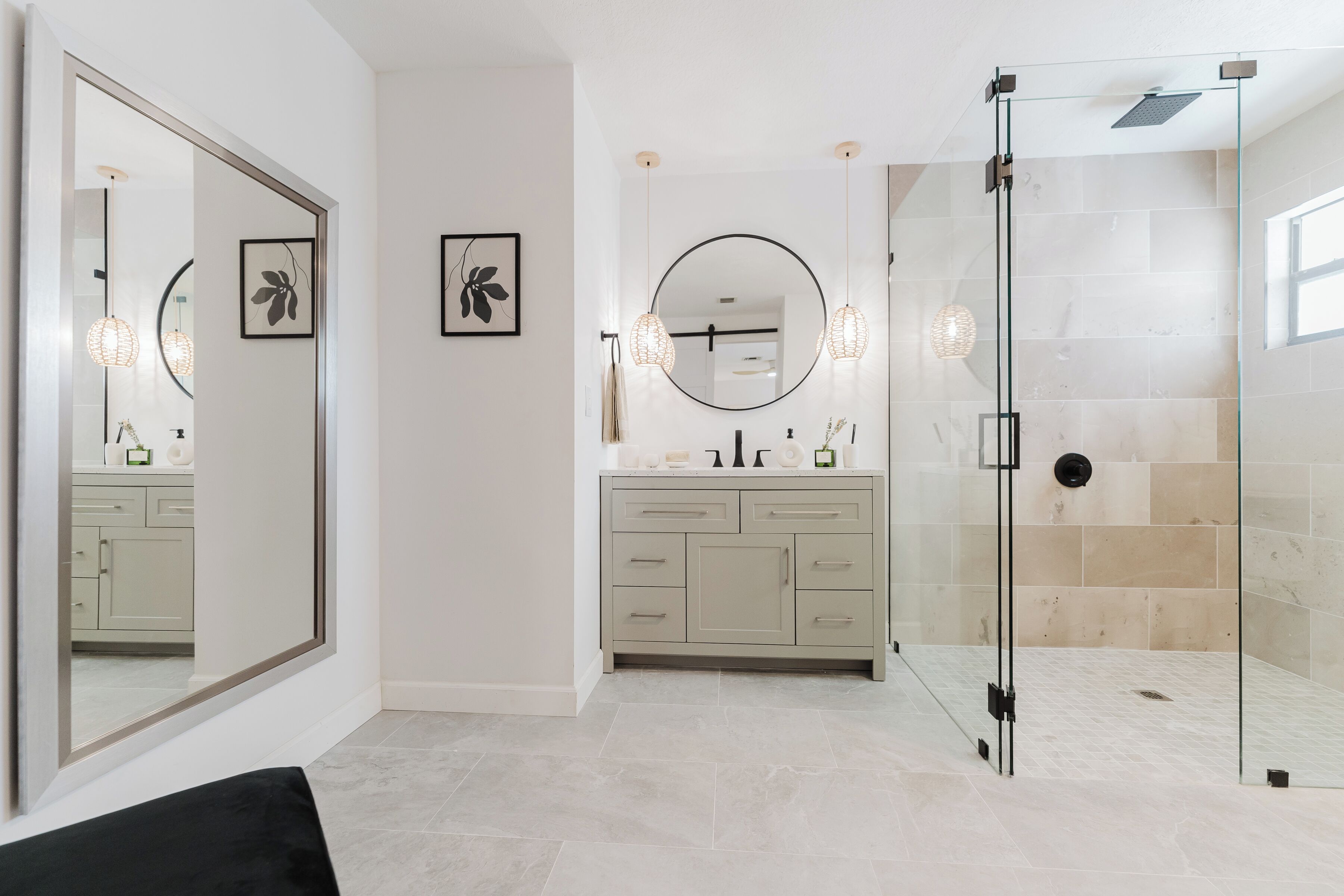 A modern bathroom with a glass-enclosed shower, a large mirror, and a vanity with a sink and countertop.