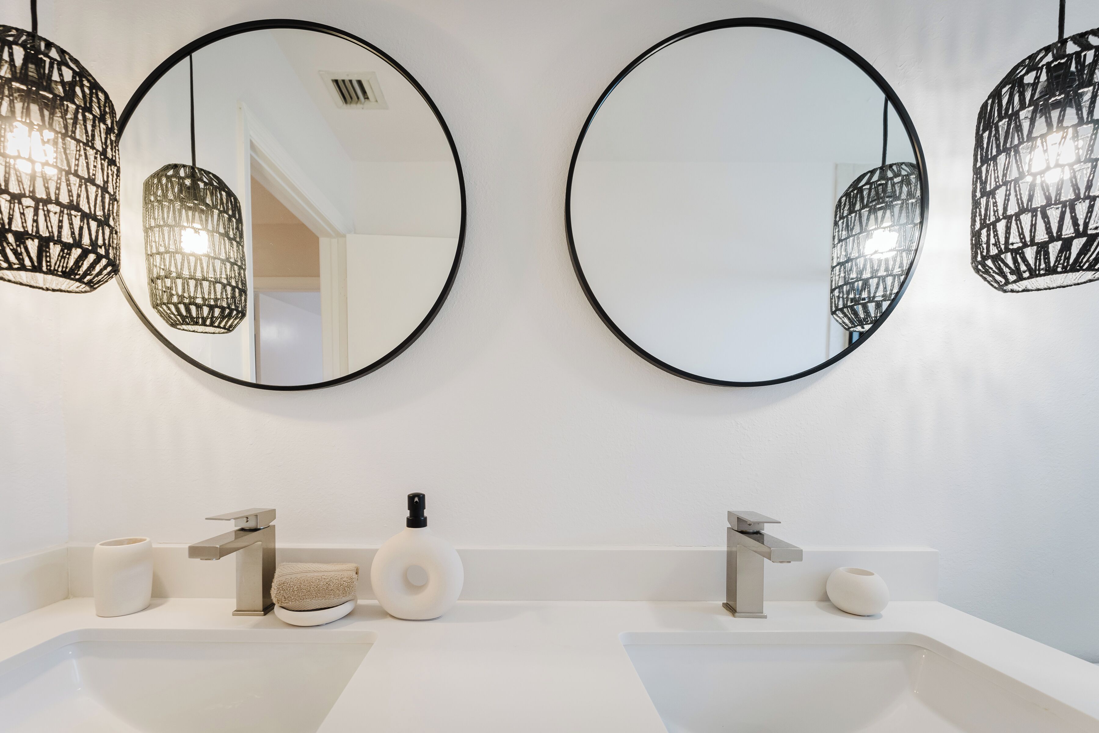 Une salle de bain moderne avec deux lavabos, des toilettes et un miroir.