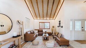 A cozy living room with a brown leather sofa, a wooden coffee table, and a patterned rug. - Tulum Villa (Pembroke Pines)