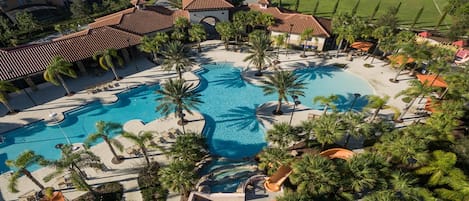 Un complexe hôtelier doté de plusieurs piscines, de palmiers et d’une pelouse bien entretenue.