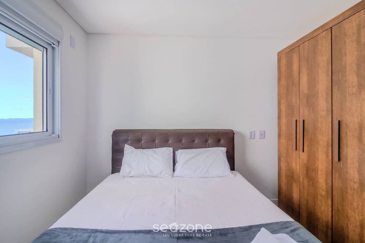 A bedroom with a bed, a window, and a wardrobe.