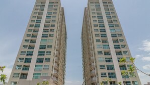 A high-rise residential building with multiple balconies, large windows, and a clear sky. - Seafront Condominium With Pool - SHC (Picarras)