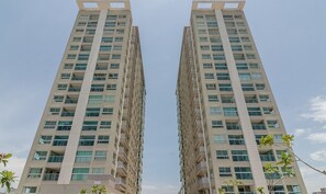 Un edificio de gran altura con varios pisos, ventanas amplias y balcones.