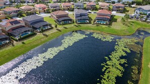 A residential area with houses, a lake, and solar panels on rooftops. - Last Minute Disney Getaway! Villa with Private Pool & Hot Tub. Book Now! #116909 (Orlando)