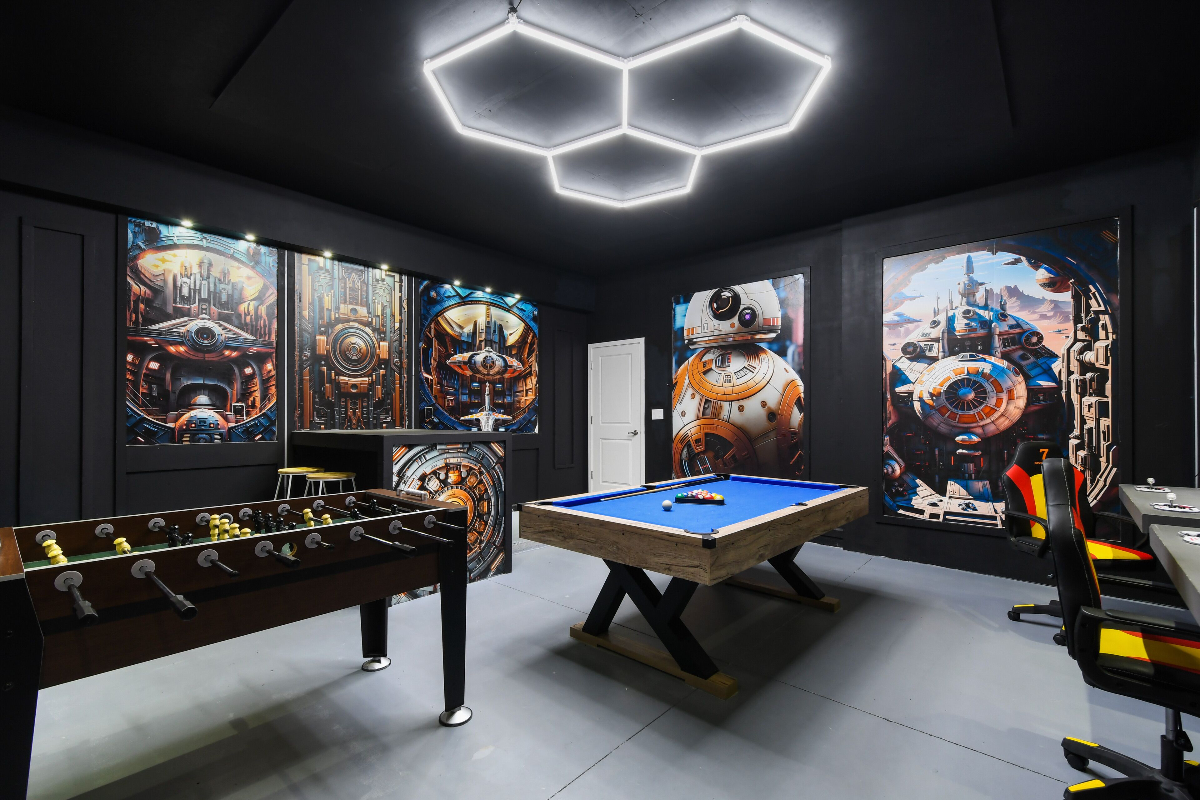 Ein Raum mit Tischfußball, Billardtisch und Star-Wars-Motiven an den Wänden.