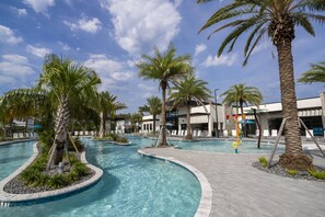 A swimming pool area with palm trees, a water slide, and a building with a modern design. - Disney! Private Pool, Game Room & Themed Bedrooms. Book Now! #PG25 (Orlando)