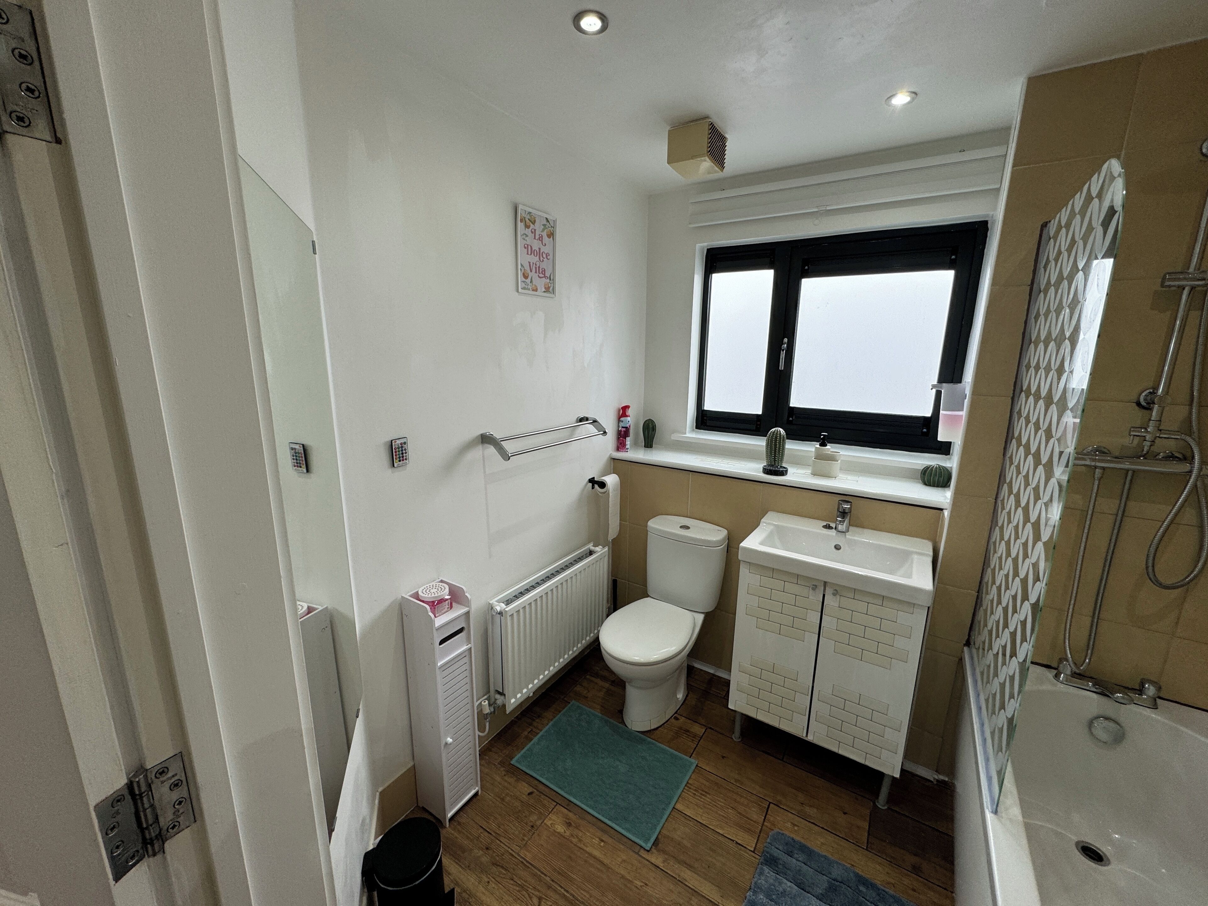 A compact bathroom with a toilet, sink, and shower.
