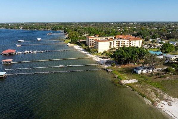 A coastal hotel with multiple buildings, a dock with boats, and a sandy beach. - LakeFront Sebring Sunsets (Sebring)