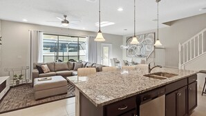 A modern kitchen with granite countertops, a built-in sink, and pendant lighting. - Last Minute Disney Getaway! Private Pool & Themed Bedrooms. Book Now! #65821 (Orlando)