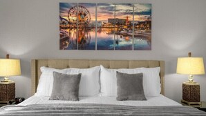 A hotel room with a large bed, two bedside lamps, and a cityscape artwork on the wall. - Last Minute Disney Getaway! Private Pool & Themed Bedrooms. Book Now! #66159 (Orlando)