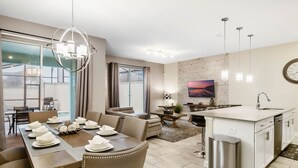 A modern living space with a dining area, kitchen, and seating area. - Last Minute Disney Getaway! Private Pool & Themed Bedrooms. Book Now! #65921 (Orlando)