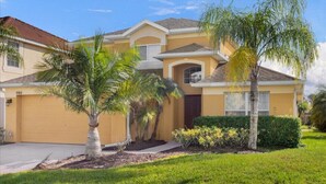 A residential house with a garage, palm trees, and a well-maintained lawn. - Last Minute Disney! Private Pool, Game Room & Themed Bedrooms. Book Now! #65689 (Orlando)
