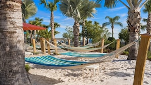 Una playa con hamacas y palmeras.
