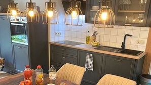 Eine moderne Küche mit einem Holztisch, gedeckt für das Frühstück, mit einer Auswahl an Speisen und Getränken.