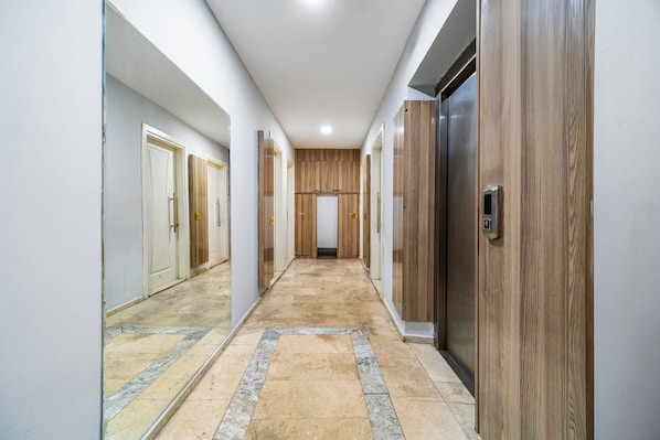 A hallway with a central door, flanked by wooden doors on either side, leading to a room with a wooden finish. - Silver Suit (Izmir)