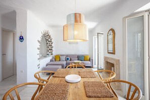 Enjoy dining in this inviting space with a table set for four, a fireplace, and a large mirror.