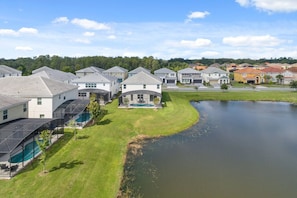 A residential area with houses, a swimming pool, and a pond. - Last Minute Disney Getaway! Private Pool & Themed Bedrooms. Book Now! #115487 (Orlando)