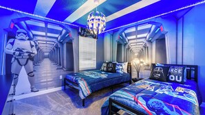 Un dormitorio temático de Star Wars con una cama, un personaje de Star Wars y un pasillo.