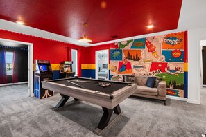 A pool table in a room with red walls and a comic book mural. - Last Minute Disney! Private Pool, Game Room & Themed Bedrooms. Book Now! #115455 (Orlando)