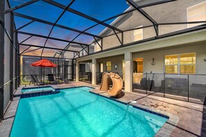 A swimming pool with a slide, enclosed patio area, and outdoor seating. - Last Minute Disney! Private Pool, Game Room & Themed Bedrooms. Book Now! #115455 (Orlando)