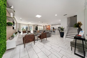 A modern open-plan living area with a kitchen, dining space, and a staircase. - Last Minute Disney Getaway! Luxury Villa with Private Pool. Book Now! #115463 (Orlando)