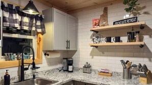 Een keuken met granieten aanrecht, een koffiezetapparaat en een bord met de tekst 'JERICO SUITE RETREAT'.
