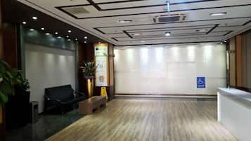 A reception area with a wooden floor, a reception desk, a bench, and a wheelchair-accessible sign.