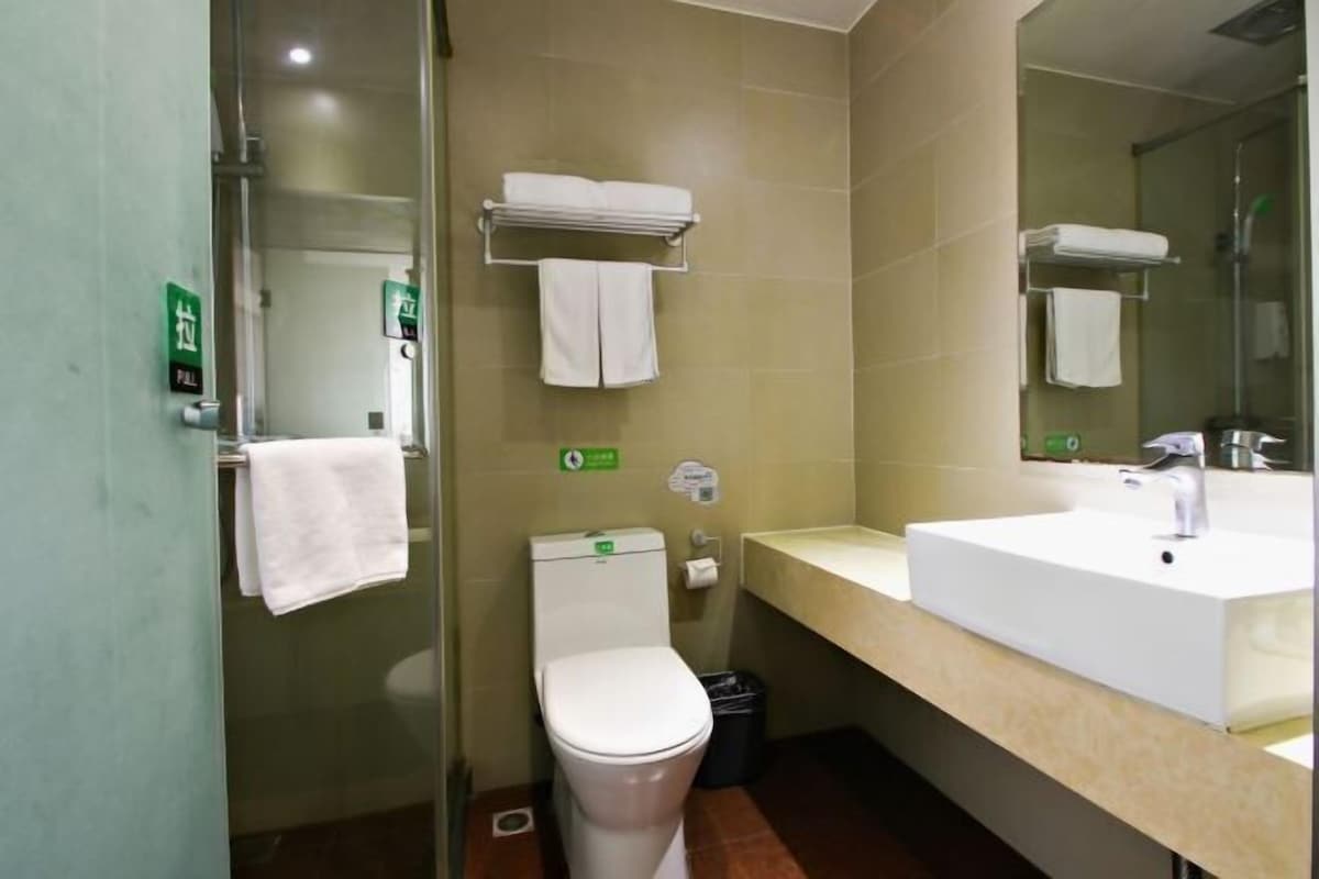 Ein Badezimmer mit Toilette, Waschbecken und Handtuchhalter.