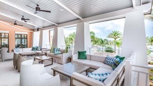 An outdoor patio area with seating arrangements, ceiling fans, and a view of palm trees. - Last Minute Disney! Private Pool, Hot Tub & Themed Bedrooms. Book Now! #124375 (Orlando)