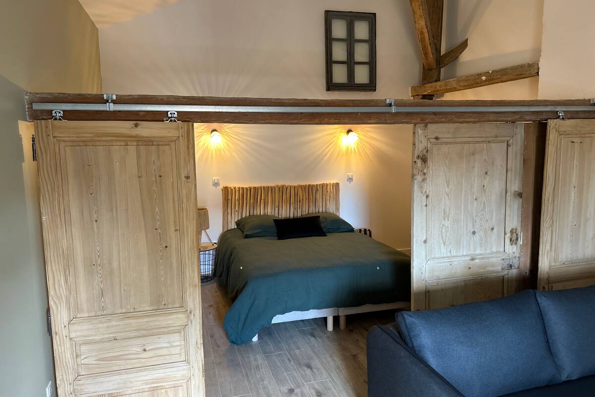 Une chambre à coucher avec un lit, une armoire en bois et un canapé.