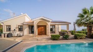 A modern house with a swimming pool, a covered patio, and a view of the sea. - Villa Pleiades - sea views, private pool & hot tub (Kouklia)