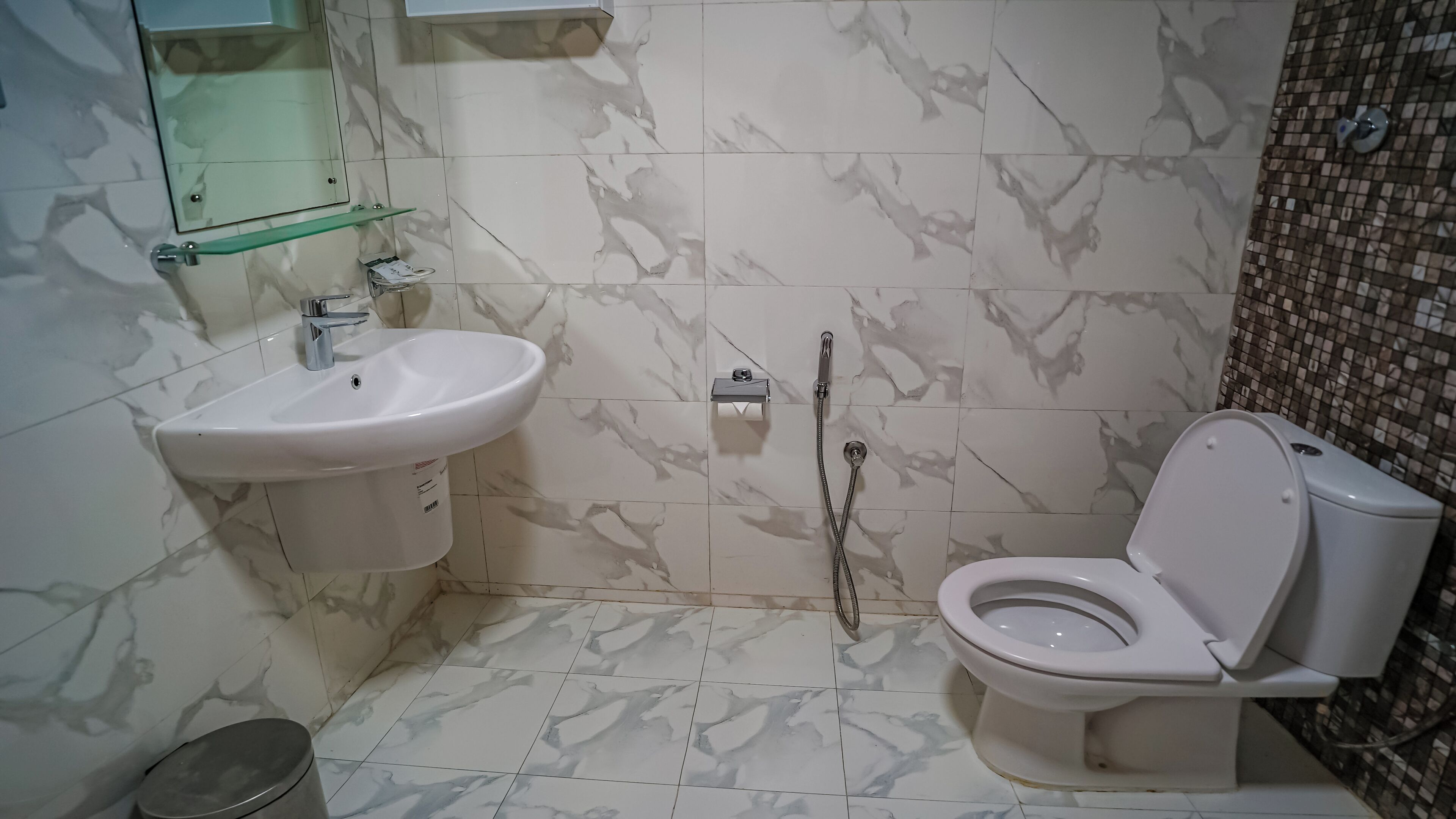 A bathroom with a white sink, a toilet, and a shower.