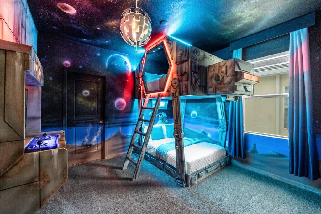 Una habitación con literas, una escalera, un escritorio y un globo terráqueo.