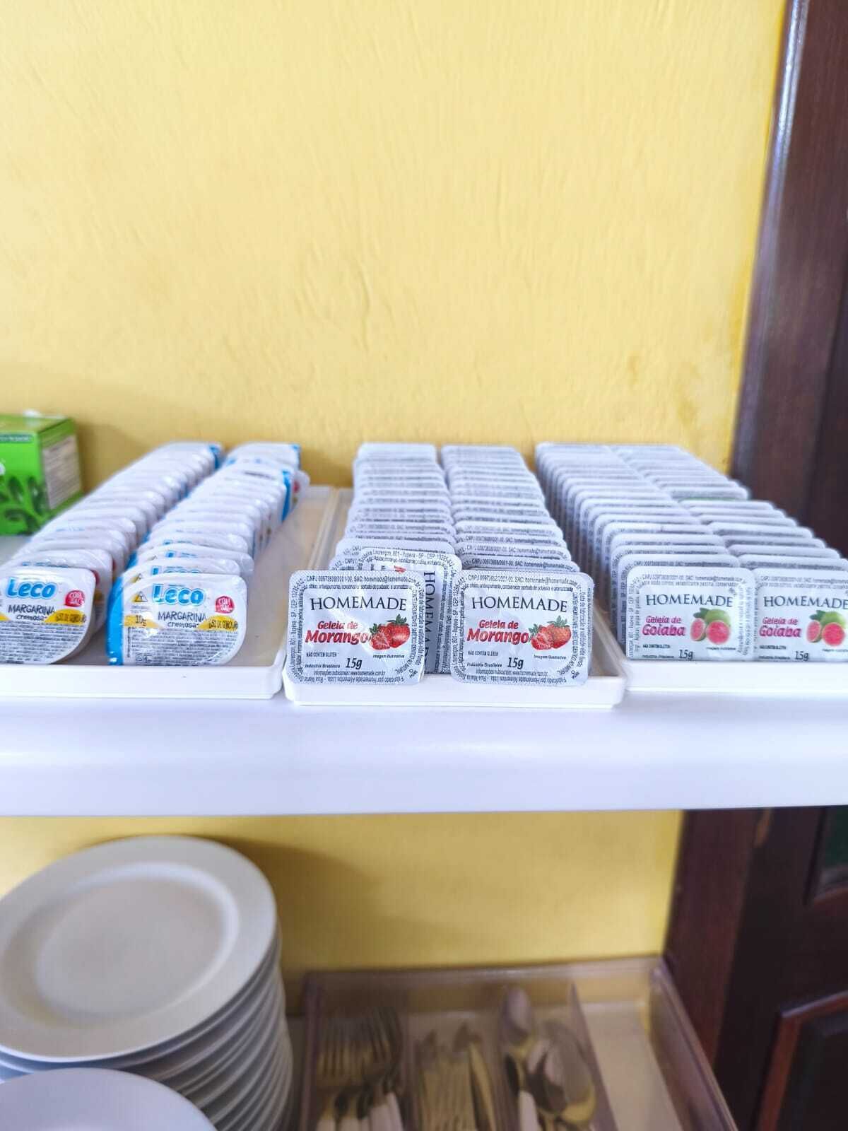 A shelf with multiple rows of packaged goods, possibly food items, with labels indicating they are homemade.