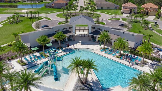 A modern hotel with a central courtyard pool, surrounded by palm trees and lounge chairs. - Last Minute Disney Getaway! Private Pool, Hot Tub & Game Room. Book Now! #65763 (Orlando)