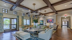 A spacious living room with a high ceiling, large windows, and a modern chandelier. - Last Minute Disney Getaway! Private Pool, Hot Tub & Game Room. Book Now! #118999 (Orlando)