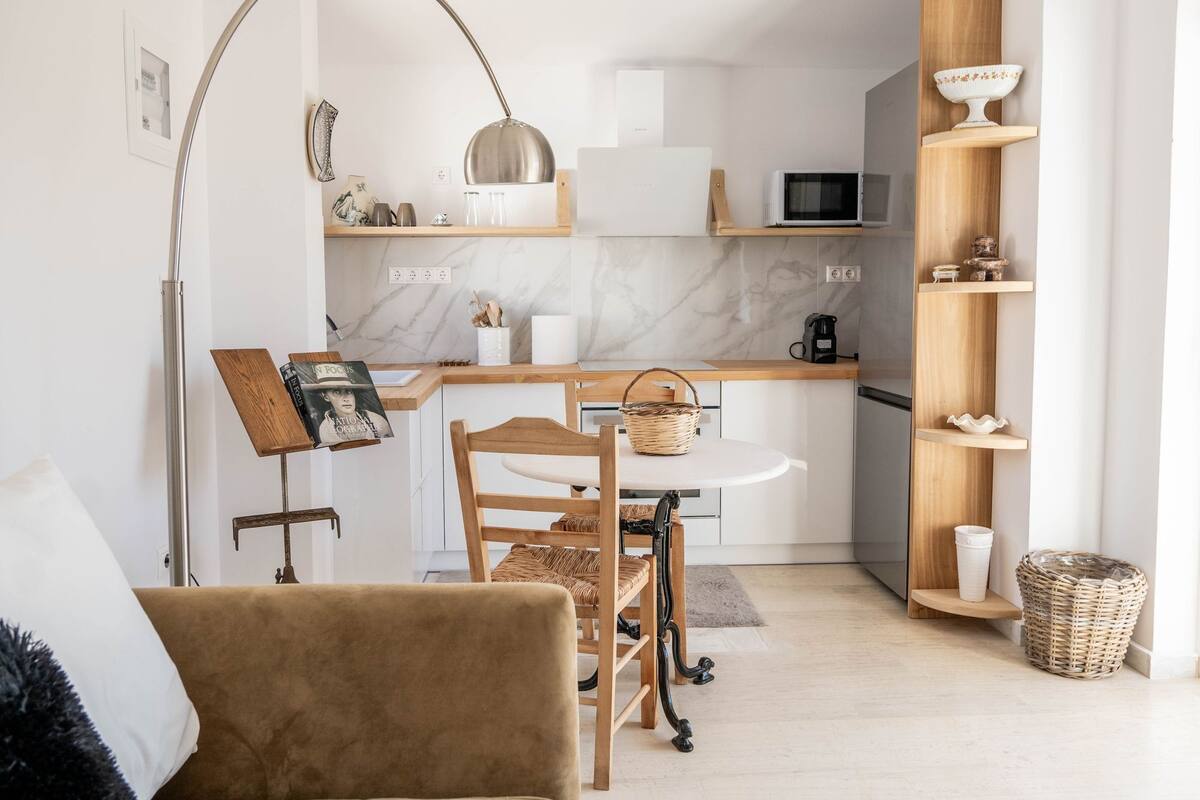 A compact living space with a kitchenette, a dining area, and a seating area with a sofa and a coffee table.